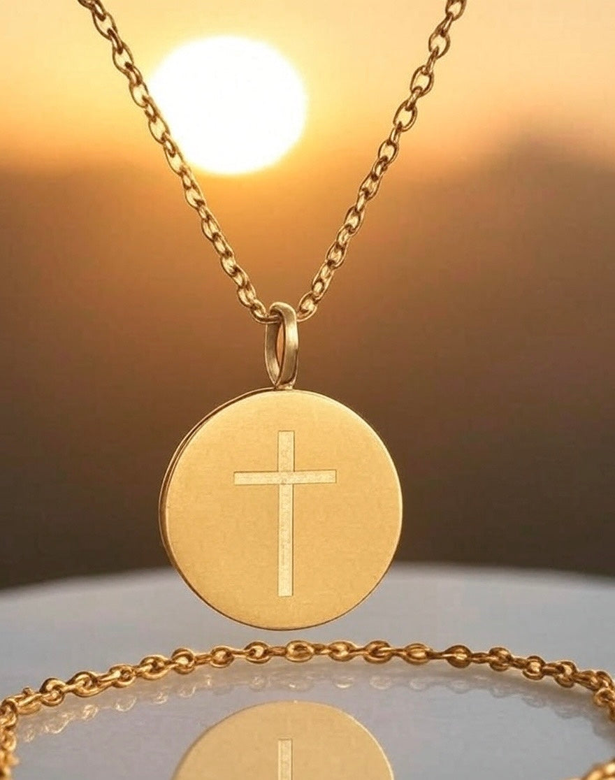 Gold necklace with a cross pendant against a warm background