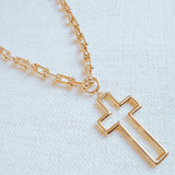 A gold cross pendant necklace on a U-shaped chain